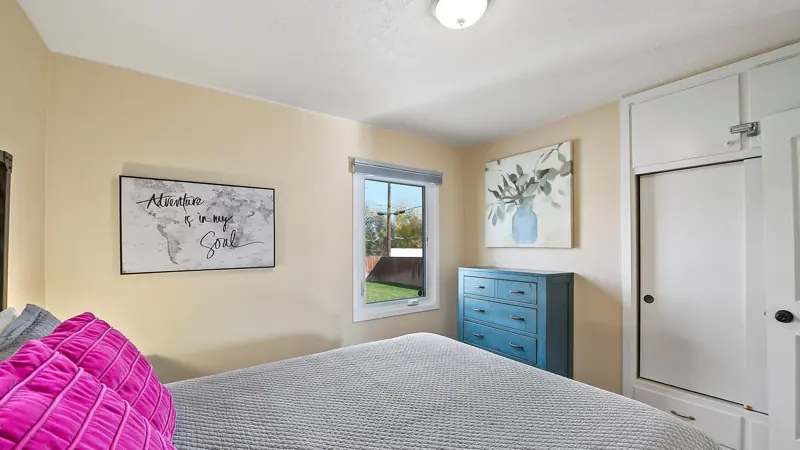 Second bedroom with a teal dresser, a window and a built-in closet.