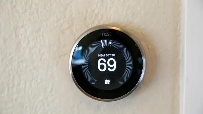 Nest thermostat on the wall showing 69 degrees.