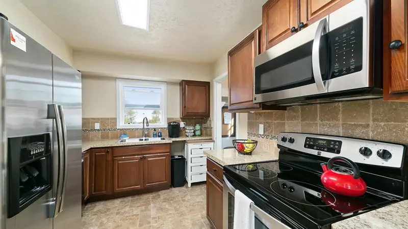 Kitchen with wood cabinets, a stainless refrigerator, an electric range and an over-the-range microwave.