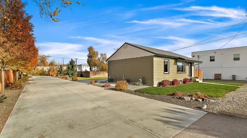 Concrete driveway leading past the side of the home.