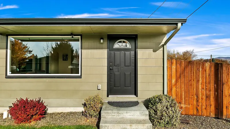 Front door with a picture window and a small porch step.